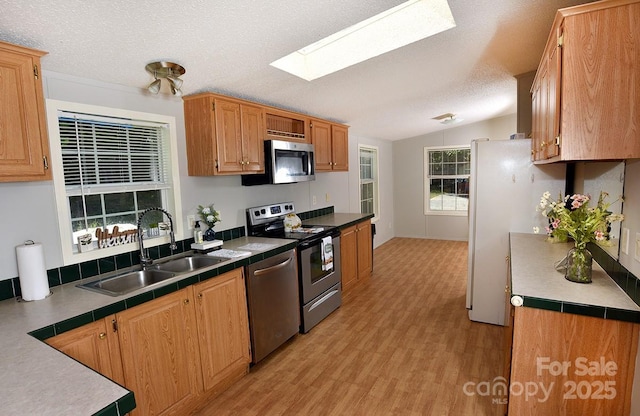 1924 Junction Rd, Mocksville, NC 27028 - kitchen with stainless steel appliances, a skylight, vaulted ceiling, a textured ceiling, and light wood-type flooring