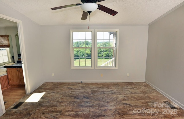 1924 Junction Rd, Mocksville, NC 27028 - spare room featuring plenty of natural light, a textured ceiling, a ceiling fan, stone finish flooring, and crown molding