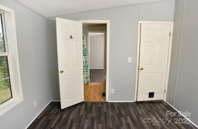 1924 Junction Rd, Mocksville, NC 27028 - unfurnished bedroom featuring dark wood-type flooring, a decorative wall, and a textured ceiling