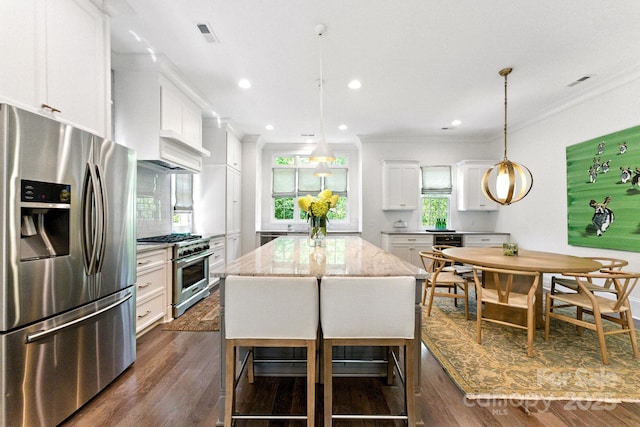 1614 Lombardy Cir, Charlotte, NC 28203 - kitchen featuring appliances with stainless steel finishes, ornamental molding, dark wood finished floors, white cabinets, and light stone counters