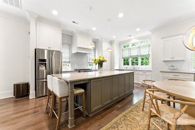 1614 Lombardy Cir, Charlotte, NC 28203 - kitchen with stainless steel fridge, a kitchen island, light stone counters, tasteful backsplash, and white cabinetry