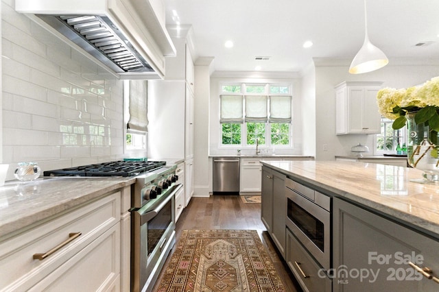 1614 Lombardy Cir, Charlotte, NC 28203 - kitchen featuring stainless steel appliances, wall chimney range hood, tasteful backsplash, light stone counters, and dark wood finished floors