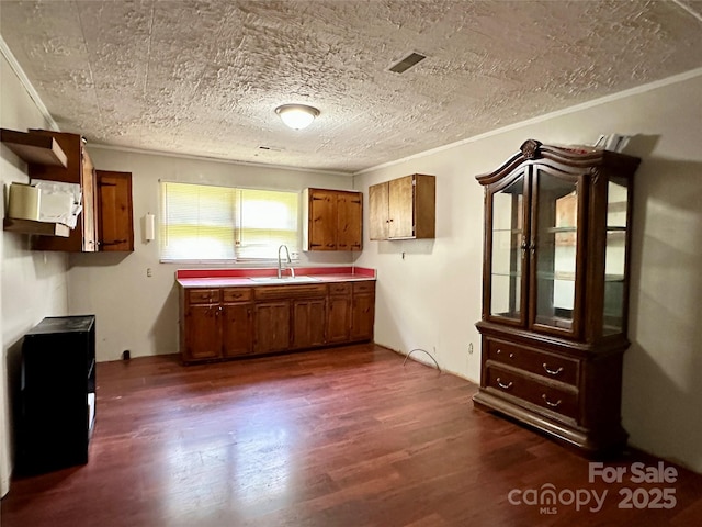 4207 Peach Orchard Rd, Granite Falls, NC 28630 - kitchen featuring brown cabinets, dark wood finished floors, light countertops, crown molding, and a textured ceiling