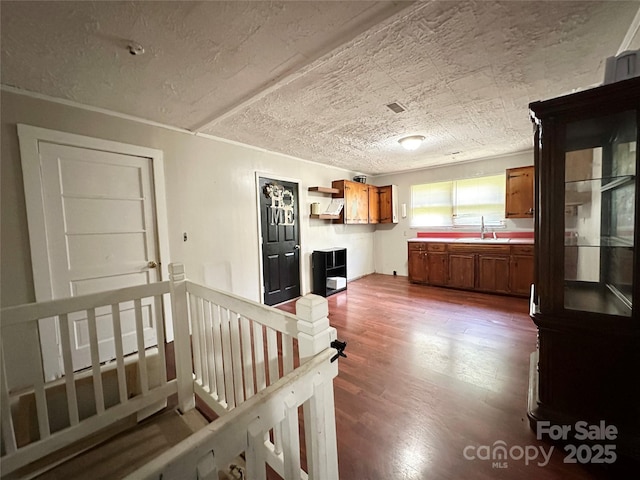 4207 Peach Orchard Rd, Granite Falls, NC 28630 - kitchen with brown cabinetry, a textured ceiling, dark wood-style floors, light countertops, and open shelves