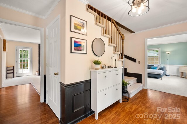 586 Crestside Dr SE, Concord, NC 28025 - hallway with stairway, wood finished floors, ornamental molding, healthy amount of natural light, and wainscoting