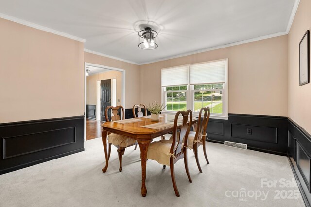 586 Crestside Dr SE, Concord, NC 28025 - dining space featuring light carpet, crown molding, and wainscoting