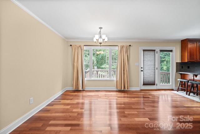 1566 Mayfair Dr, Conover, NC 28613 - unfurnished dining area featuring a chandelier, plenty of natural light, crown molding, and light wood-style flooring