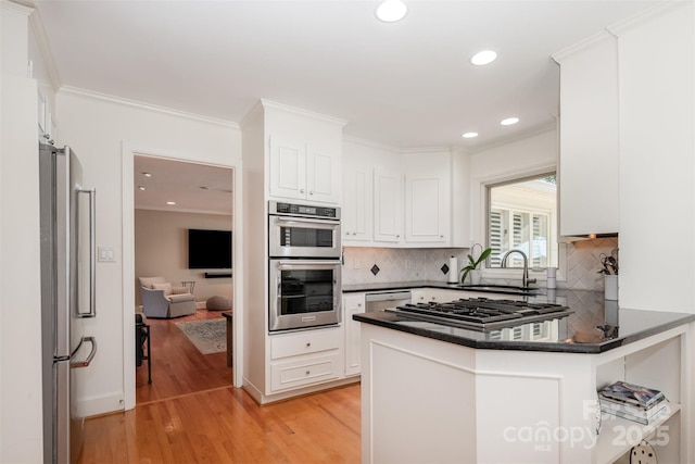 7119 Folger Dr, Charlotte, NC 28270 - kitchen with appliances with stainless steel finishes, light wood-type flooring, white cabinetry, dark countertops, and recessed lighting