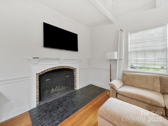 105 Edgewood Cir NE, Concord, NC 28025 - living room featuring wood-type flooring, a fireplace, beamed ceiling, wainscoting, and ornamental molding
