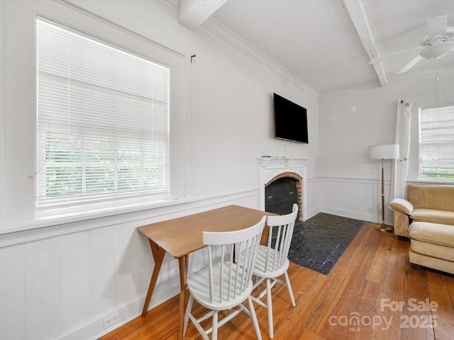105 Edgewood Cir NE, Concord, NC 28025 - dining space featuring hardwood / wood-style flooring, a decorative wall, ceiling fan, a brick fireplace, and beam ceiling