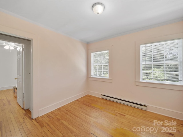 105 Edgewood Cir NE, Concord, NC 28025 - empty room featuring a baseboard heating unit, plenty of natural light, light wood-style flooring, and crown molding