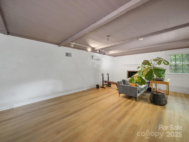 105 Edgewood Cir NE, Concord, NC 28025 - living area featuring wood finished floors, a brick fireplace, a wall mounted AC, and a wood ceiling with exposed beams