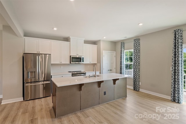342 Cramerton Mills Parkway, Cramerton, NC 28032 - kitchen featuring appliances with stainless steel finishes, white cabinets, light wood-type flooring, decorative backsplash, and recessed lighting