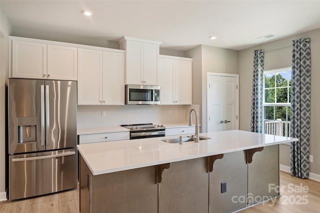 342 Cramerton Mills Parkway, Cramerton, NC 28032 - kitchen featuring appliances with stainless steel finishes, white cabinets, a kitchen island with sink, a kitchen bar, and recessed lighting