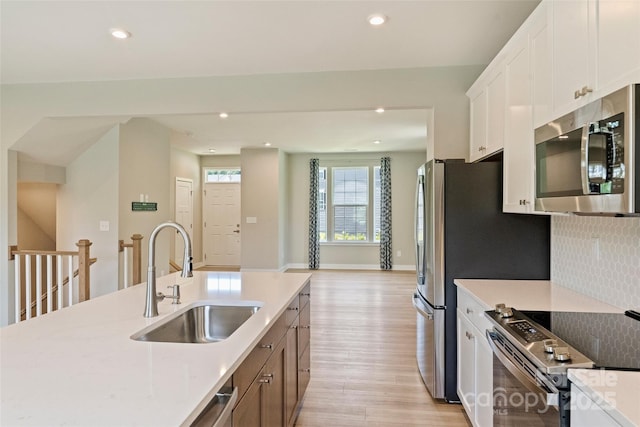 342 Cramerton Mills Parkway, Cramerton, NC 28032 - kitchen featuring stainless steel appliances, light wood-type flooring, tasteful backsplash, white cabinets, and recessed lighting