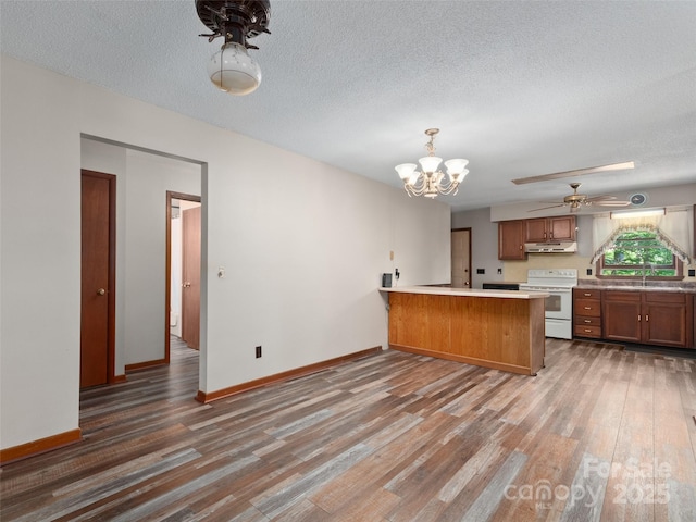 250 Turkey Pen Rd, Franklin, NC 28734 - kitchen with white electric range oven, a peninsula, light wood-style floors, brown cabinetry, and a chandelier