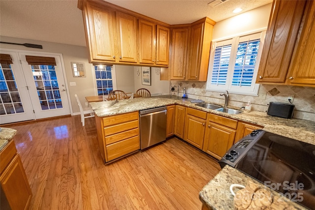 696 Springwood Dr, Mount Gilead, NC 27306 - kitchen featuring stainless steel dishwasher, light wood-style floors, a peninsula, light stone counters, and a textured ceiling
