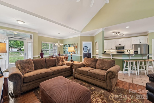 3865 Willow Grove Ln, Concord, NC 28025 - living room featuring a chandelier, lofted ceiling, ornamental molding, and wood finished floors