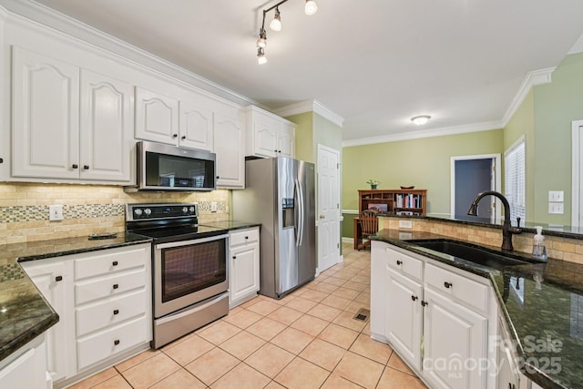 3865 Willow Grove Ln, Concord, NC 28025 - kitchen with appliances with stainless steel finishes, decorative backsplash, white cabinetry, ornamental molding, and light tile patterned flooring