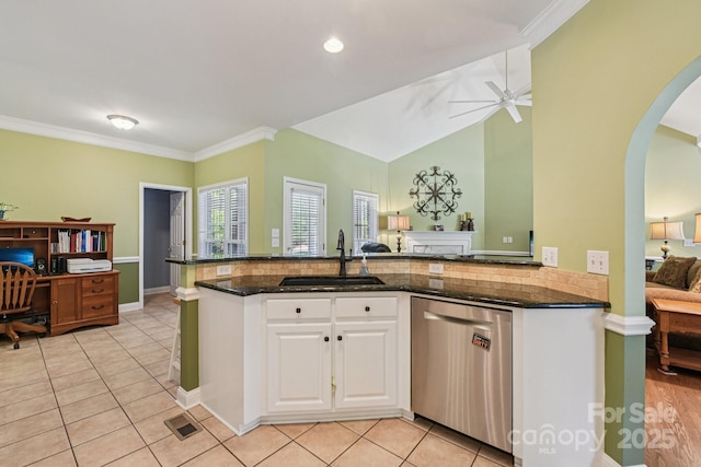 3865 Willow Grove Ln, Concord, NC 28025 - kitchen featuring stainless steel dishwasher, ceiling fan, arched walkways, dark stone counters, and white cabinetry