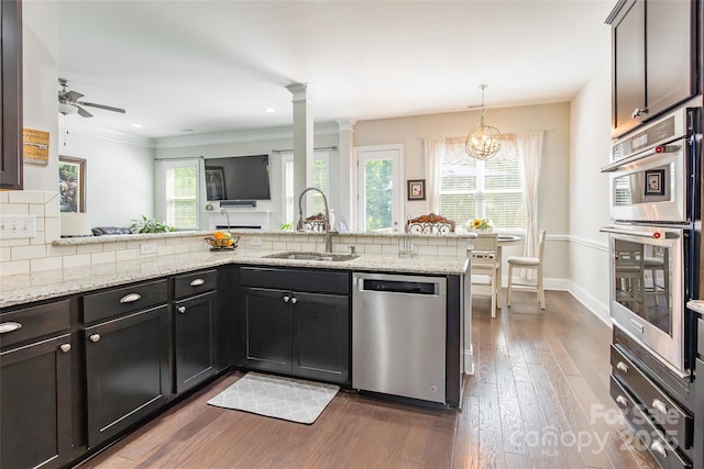 461 Swift Creek Cv, Clover, SC 29710 - kitchen featuring stainless steel appliances, dark wood-style flooring, light stone countertops, a ceiling fan, and ornamental molding