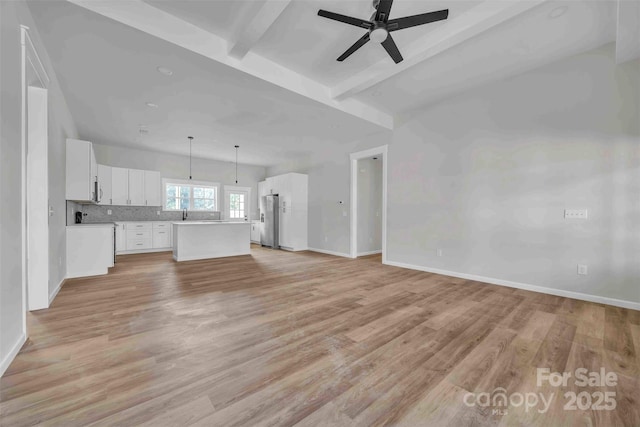 2325 32nd St NE, Hickory, NC 28601 - unfurnished living room featuring light wood finished floors, beam ceiling, and a ceiling fan