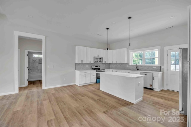 2325 32nd St NE, Hickory, NC 28601 - kitchen with appliances with stainless steel finishes, light countertops, backsplash, white cabinets, and light wood-style flooring