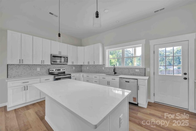 2325 32nd St NE, Hickory, NC 28601 - kitchen featuring stainless steel appliances, light wood-style floors, light countertops, and decorative backsplash