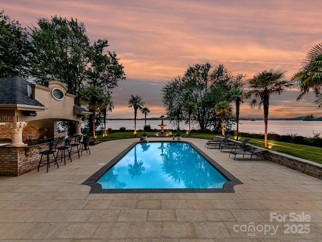 18201 Mainsail Pointe Dr, Cornelius, NC 28031 - pool at dusk featuring a patio area, a water view, and an outdoor pool