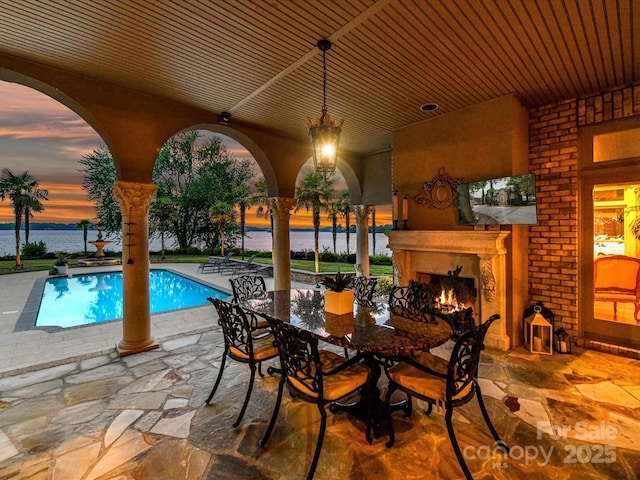 18201 Mainsail Pointe Dr, Cornelius, NC 28031 - pool at dusk with a patio, a warm lit fireplace, an outdoor pool, and a water view