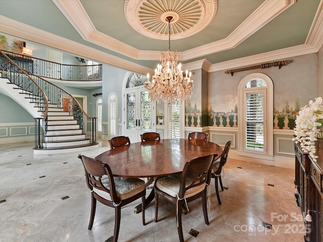 18201 Mainsail Pointe Dr, Cornelius, NC 28031 - dining room with a decorative wall, stairway, a raised ceiling, crown molding, and a chandelier