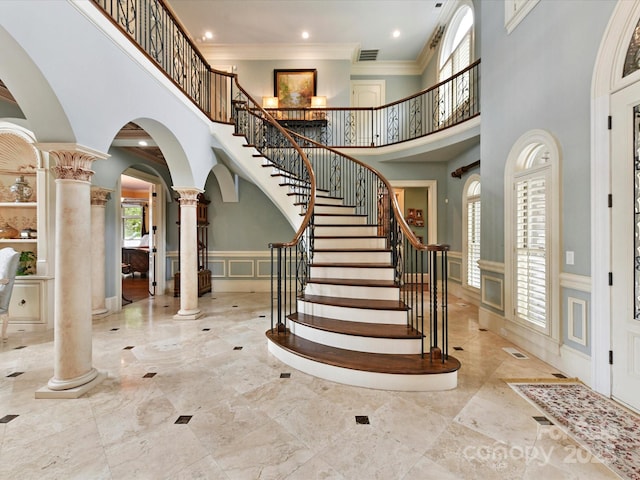 18201 Mainsail Pointe Dr, Cornelius, NC 28031 - foyer featuring ornate columns, a decorative wall, a high ceiling, arched walkways, and wainscoting