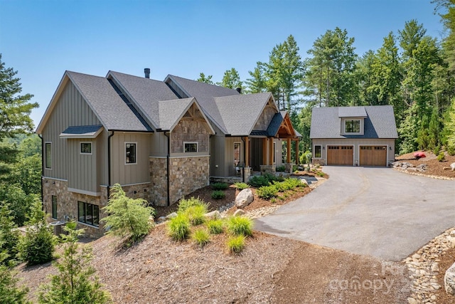 256 Hunt Camp Dr, Nebo, NC 28761 - view of front facade featuring stone siding, an outdoor structure, board and batten siding, a detached garage, and covered porch