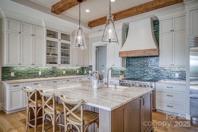 256 Hunt Camp Dr, Nebo, NC 28761 - kitchen featuring beam ceiling, light wood-type flooring, custom exhaust hood, decorative backsplash, and a kitchen island with sink