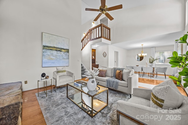 9008 St Croix Ln, Charlotte, NC 28277 - living room with stairway, wood finished floors, ceiling fan, a towering ceiling, and a chandelier