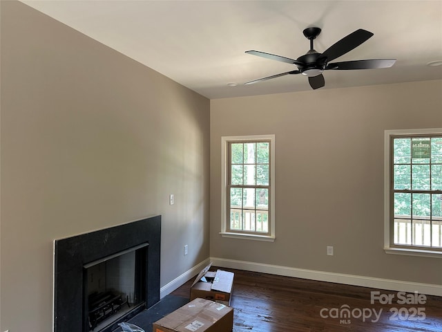 1031 Long Dr, Newton, NC 28658 - unfurnished living room featuring plenty of natural light, wood finished floors, a ceiling fan, and a fireplace with flush hearth