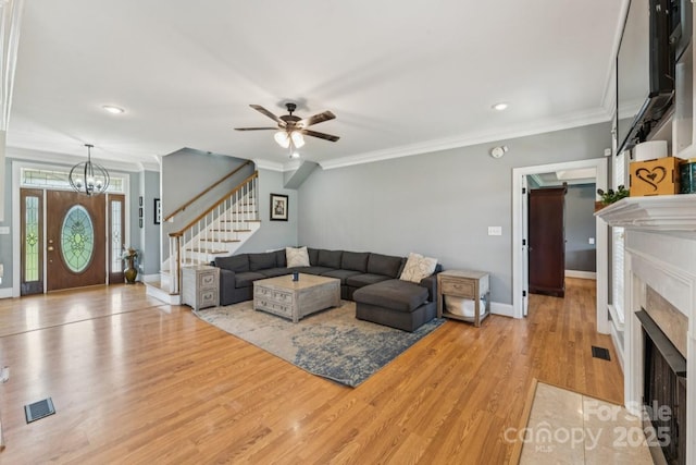 1123 Snyders Store Rd, Wingate, NC 28174 - living area featuring stairway, light wood-type flooring, a ceiling fan, a fireplace with flush hearth, and a chandelier