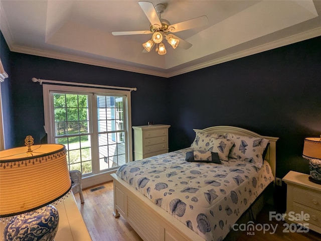 6301 Hawk Nest Dr, Concord, NC 28027 - bedroom with light wood-style flooring, a tray ceiling, a ceiling fan, and crown molding