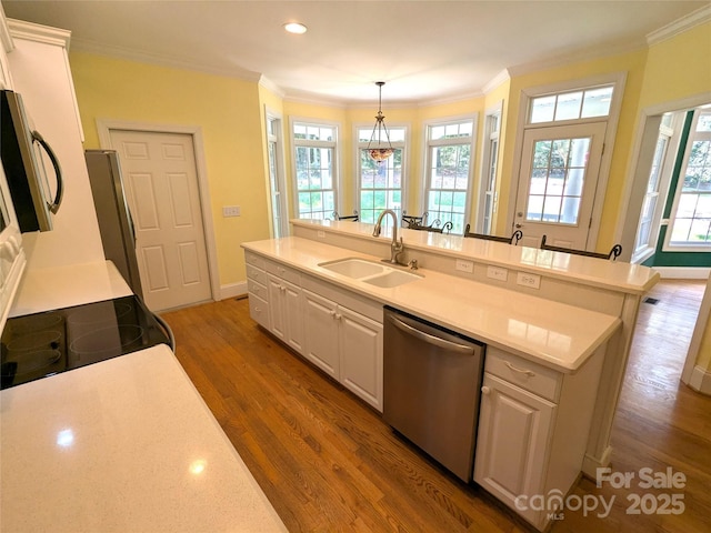 6301 Hawk Nest Dr, Concord, NC 28027 - kitchen featuring stainless steel appliances, white cabinetry, crown molding, wood finished floors, and healthy amount of natural light