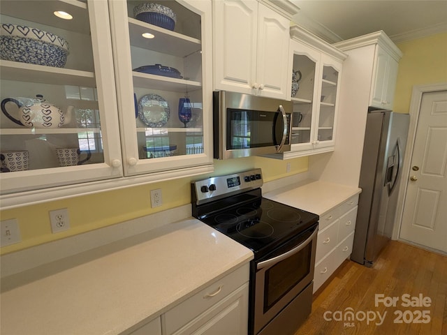 6301 Hawk Nest Dr, Concord, NC 28027 - kitchen featuring stainless steel appliances, white cabinets, light wood-type flooring, glass insert cabinets, and light countertops