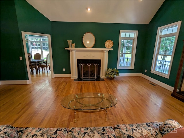 6301 Hawk Nest Dr, Concord, NC 28027 - living area featuring lofted ceiling, plenty of natural light, wood finished floors, a fireplace with flush hearth, and recessed lighting