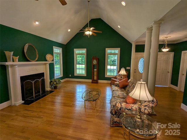 6301 Hawk Nest Dr, Concord, NC 28027 - living area with ceiling fan, decorative columns, vaulted ceiling, wood finished floors, and a fireplace with flush hearth