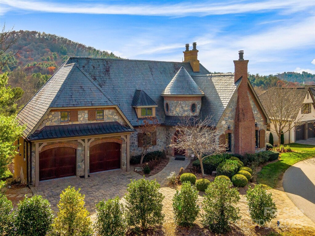 20 Snap Dragon Ct, Asheville, NC 28804 - view of front of property with stone siding, a high end roof, a chimney, a standing seam roof, and decorative driveway