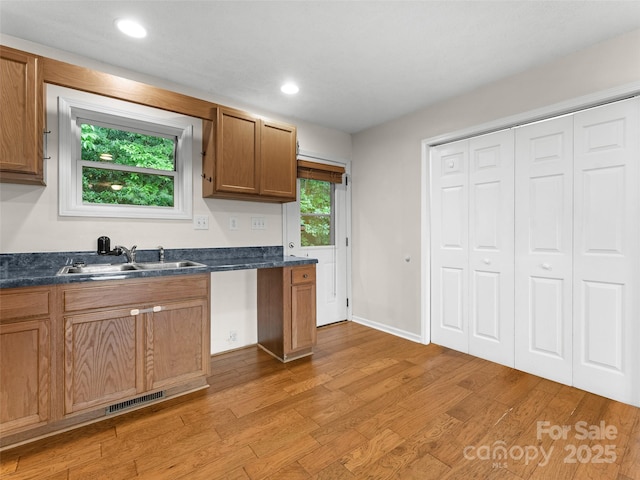 96 Habitat Way, Brevard, NC 28712 - kitchen featuring dark countertops, light wood-type flooring, brown cabinetry, and recessed lighting