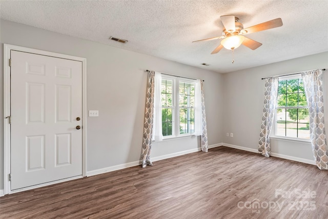 600 Piper Ct, Wingate, NC 28174 - empty room with wood finished floors, plenty of natural light, a textured ceiling, and ceiling fan