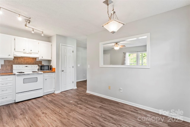 600 Piper Ct, Wingate, NC 28174 - kitchen with white electric range, under cabinet range hood, light wood finished floors, stainless steel microwave, and white cabinets