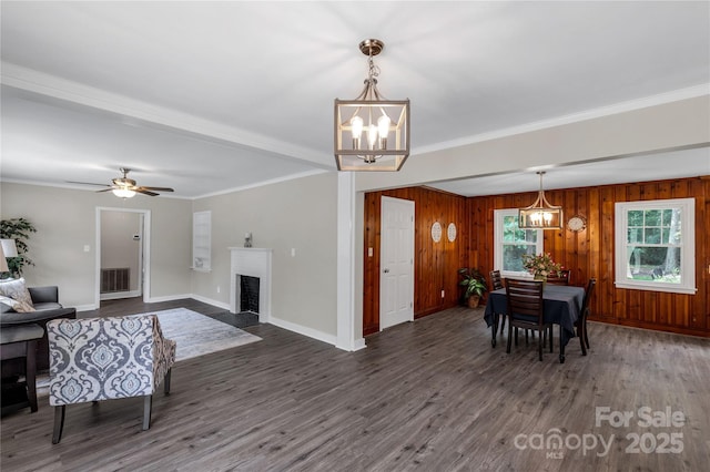 1641 Converse St, Lancaster, SC 29720 - living room with a chandelier, dark wood-type flooring, ornamental molding, a fireplace with flush hearth, and wooden walls