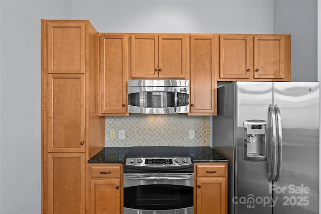 2810 Selwyn Ave Unit 429, Charlotte, NC 28209 - kitchen featuring appliances with stainless steel finishes, backsplash, dark stone counters, and brown cabinetry
