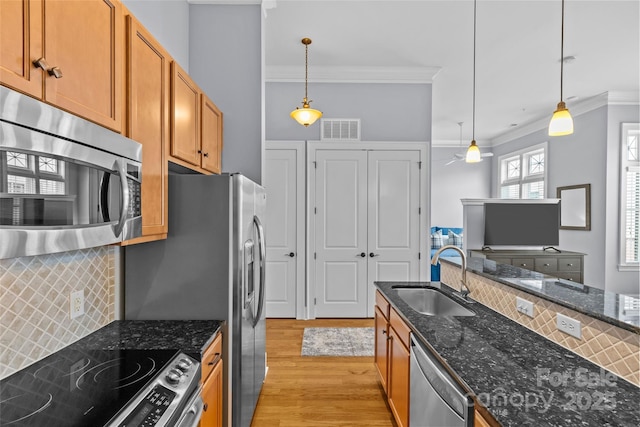 2810 Selwyn Ave Unit 429, Charlotte, NC 28209 - kitchen featuring appliances with stainless steel finishes, crown molding, tasteful backsplash, and brown cabinets