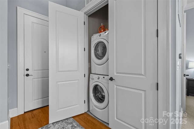 2810 Selwyn Ave Unit 429, Charlotte, NC 28209 - washroom featuring stacked washer / dryer and wood finished floors